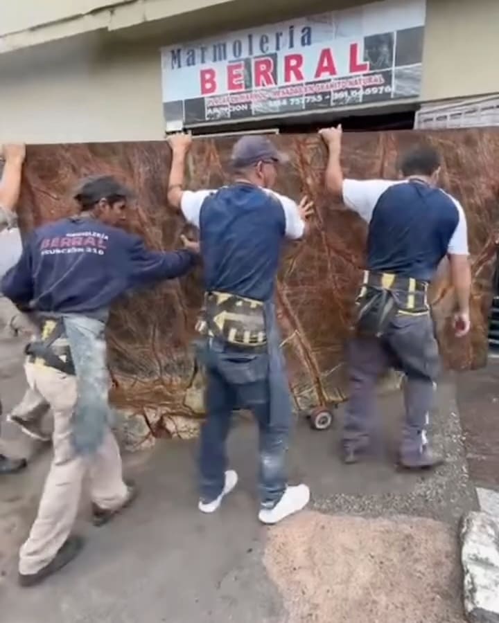 El equipo de Berral llevando una placa de piedra al local
