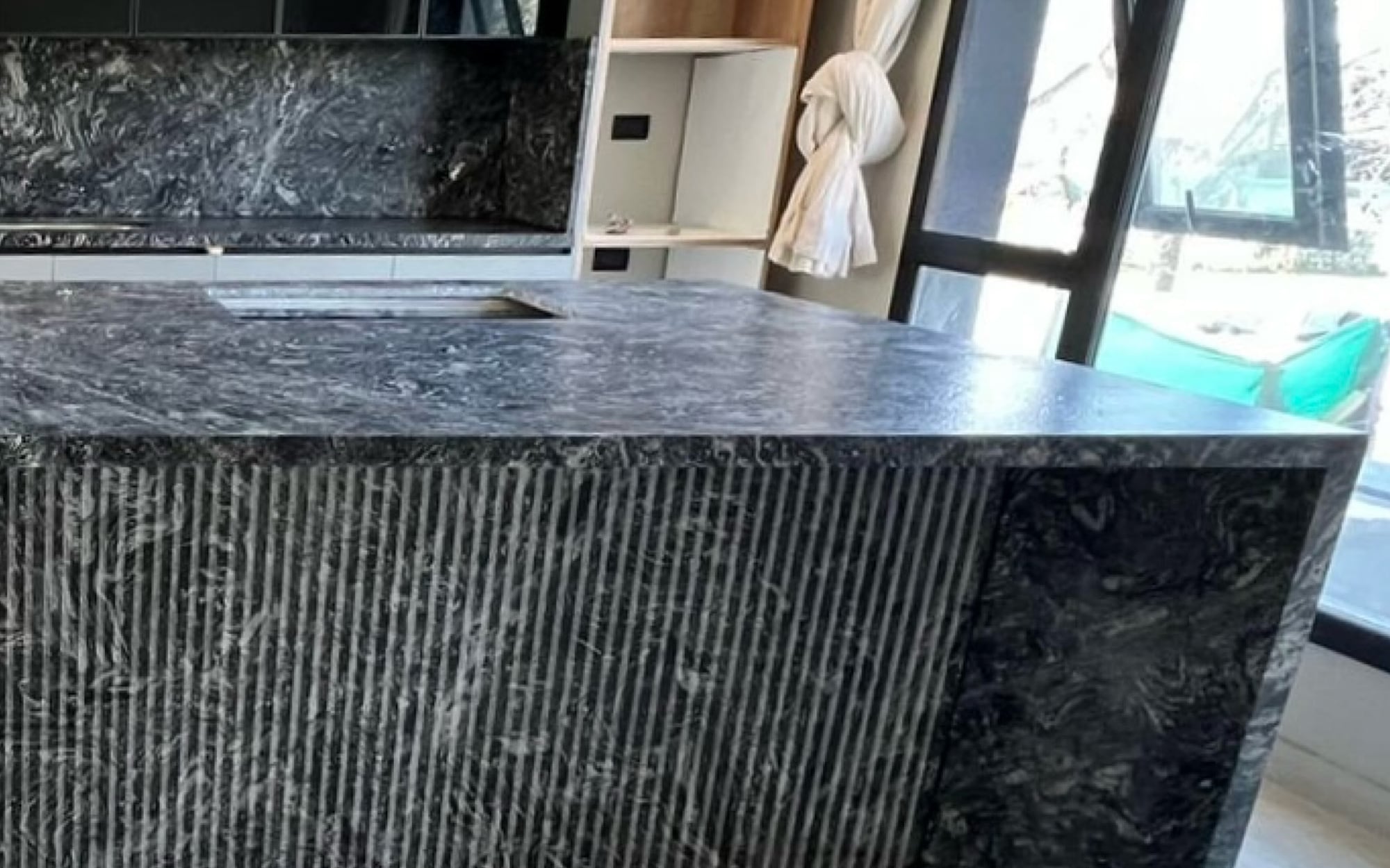Isla de cocina en granito Negro Boreal Leather con frente calado